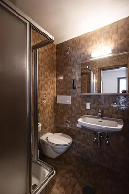 a bathroom with a toilet and a sink and a tub at Hotel Mühlwald in Selva dei Molini