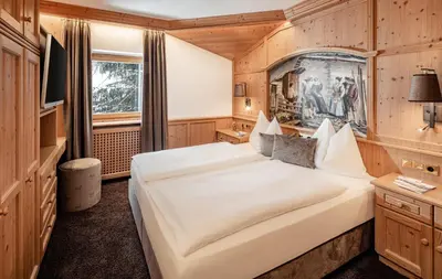 a bedroom with a large bed in a room at Suites Hotel Garden in Selva di Val Gardena