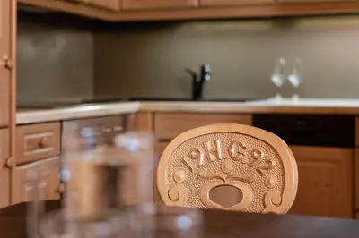 a wooden chair sitting in front of a kitchen counter at Suites Hotel Garden in Selva di Val Gardena