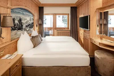 a bedroom with two beds in a room at Suites Hotel Garden in Selva di Val Gardena