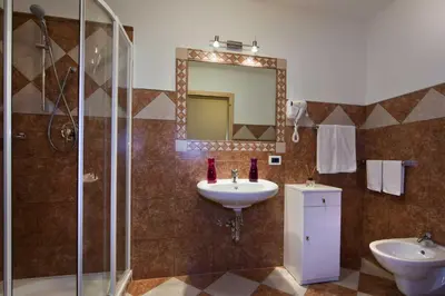 a bathroom with a sink and a shower and a mirror at Residence Merk in Selva di Val Gardena