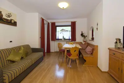 a living room with a couch and a table at Residence Merk in Selva di Val Gardena