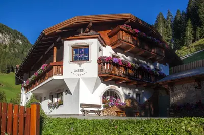a building with a balcony and flowers on it at Residence Merk in Selva di Val Gardena
