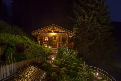a log cabin at night with lights on the stairs at Residence Merk in Selva di Val Gardena