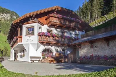 a building with balconies and flowers on it at Residence Merk in Selva di Val Gardena