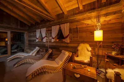 a living room with white chairs and a table at Residence Merk in Selva di Val Gardena