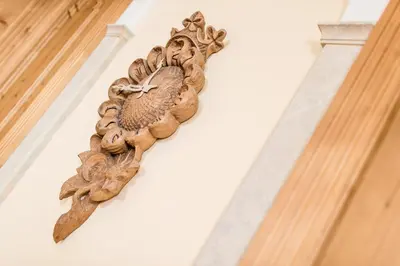 a wooden clock on the side of a building at Romantik & Family Hotel Gardenia***S in Selva di Val Gardena