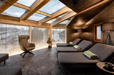 a living room with two couches and a chair at Romantik & Family Hotel Gardenia***S in Selva di Val Gardena