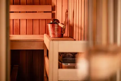 a copper bucket sitting on a shelf in a sauna at Romantik & Family Hotel Gardenia***S in Selva di Val Gardena