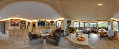 a large living room with tables and chairs at Appartamenti Ciasa Linda in San Martino in Badia