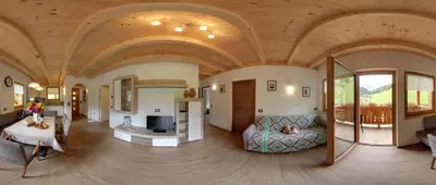 a large living room with a wooden ceiling at Appartamenti Ciasa Linda in San Martino in Badia