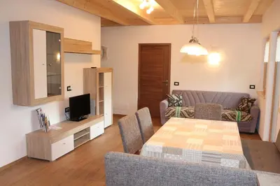 a living room with a table and a couch at Appartamenti Ciasa Linda in San Martino in Badia