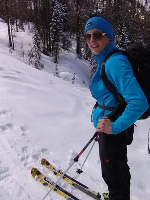 a woman is standing on skis in the snow at Appartamenti Ciasa Linda in San Martino in Badia