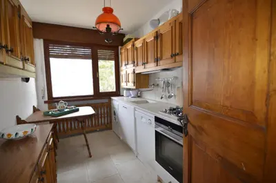 a kitchen with wooden cabinets and a white stove top oven at Overlooking the Dolomites in Cortina dʼAmpezzo