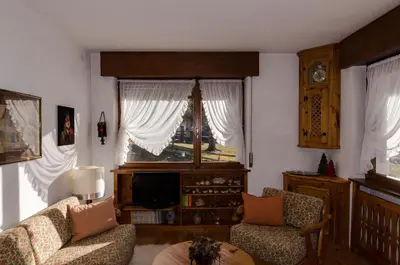 a living room with a couch and a window at Overlooking the Dolomites in Cortina dʼAmpezzo