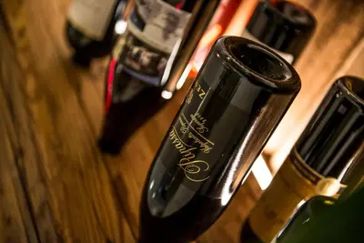 a bottle of wine sitting on a wooden table at Alpin Hotel Gudrun in Colle Isarco