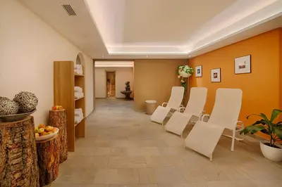 a waiting room with white chairs in a corridor at Hotel Mair in Campo Tures