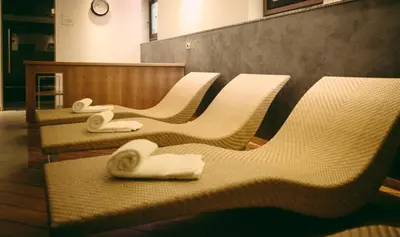 a row of white chairs with towels on them at Hotel Alla Posta - Famiglia Pra dal 1866 a Caprile in Alleghe