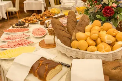 a table with bread and other foods on it at Hotel Alla Posta - Famiglia Pra dal 1866 a Caprile in Alleghe