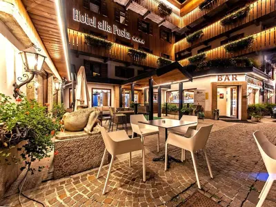 a restaurant with a table and chairs in a building at Hotel Alla Posta - Famiglia Pra dal 1866 a Caprile in Alleghe