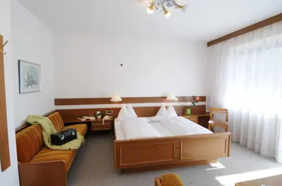 a bedroom with a large bed and a couch at Garni Weingut in Merano