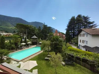 a swimming pool in a yard next to a house at Garni Weingut in Merano