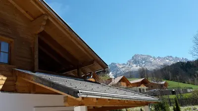 a roof of a building with mountains in the background at Haus Traudi in Nova Ponente