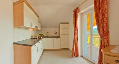 a kitchen with white cabinets and a large window at Unterstoan Hof in Termeno