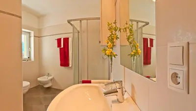 a white bathroom with a sink and a mirror at Unterstoan Hof in Termeno
