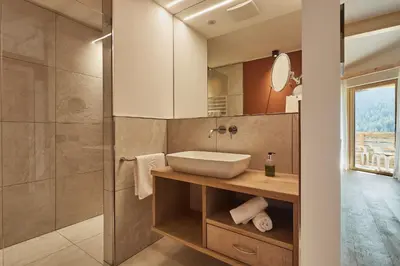a bathroom with a sink and a shower at Mountain Hotel Mezdì in Colfosco