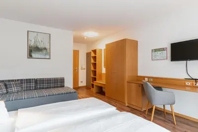 a hotel room with a bed and a tv at Hotel Brenner - Stop & Go in Vipiteno
