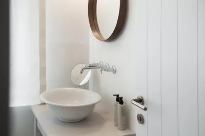a bathroom with a white sink and a mirror at 1477 Reichhalter, a Member of Design Hotels in Lana