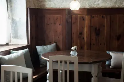 a dining room with a wooden table and white chairs at 1477 Reichhalter, a Member of Design Hotels in Lana