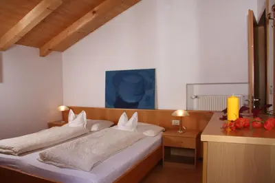a bedroom with a bed and a table with a candle at Ferienwohnungen grazia dei in Lagundo