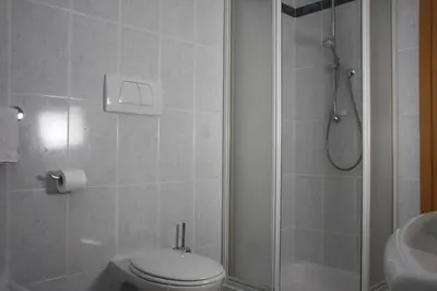 a bathroom with a shower and a toilet and a sink at Ferienwohnungen grazia dei in Lagundo