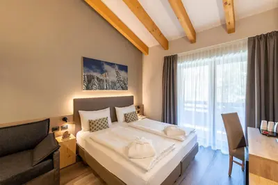 a bedroom with a large bed and a couch at Chalet Aster in Moena