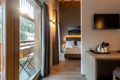 a room with a bedroom with a bed and a window at Chalet Aster in Moena