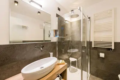 a bathroom with a sink and a glass shower at Chalet Aster in Moena