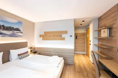 a hotel room with a bed and a desk at Chalet Aster in Moena