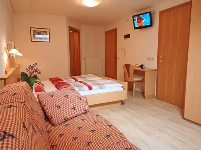 a hotel room with a bed and a tv on the wall at Residence Araldina in San Cassiano