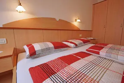 a bedroom with two beds with red and white blankets at Residence Araldina in San Cassiano
