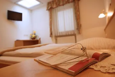 a bedroom with two beds and a table and a desk at Residence Araldina in San Cassiano