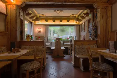 a restaurant with tables and chairs in a room at Digonera Historic Hotel B&B in Rocca Pietore