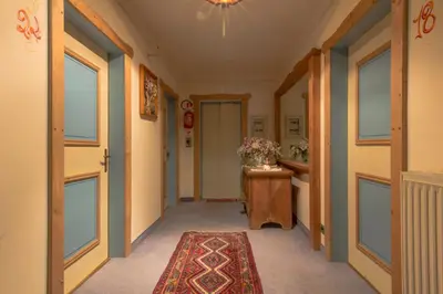 a hallway with a door and a rug at Digonera Historic Hotel B&B in Rocca Pietore