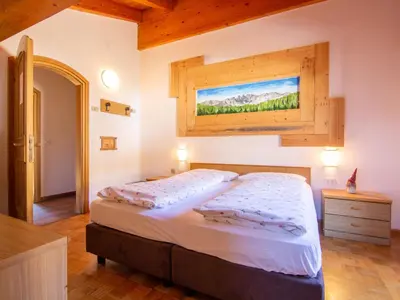 a bedroom with a large bed and a window at Apartment Garni Eden by Interhome in Soraga