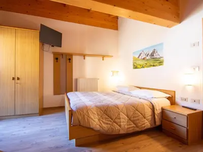 a bedroom with a bed and a painting on the wall at Apartment Garni Eden by Interhome in Soraga