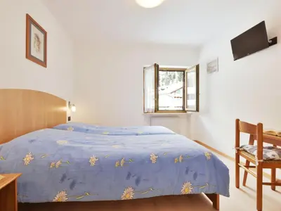 a bedroom with two beds and a window at Apartment Bernard-3 by Interhome in Campestrin