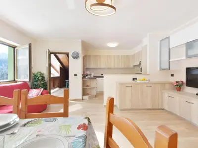 a kitchen with white cabinets and a tv in it at Apartment Bernard-3 by Interhome in Campestrin