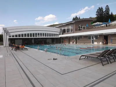 a large swimming pool in front of a building at Hotel Roen Ruffrè-Mendola in Mendola