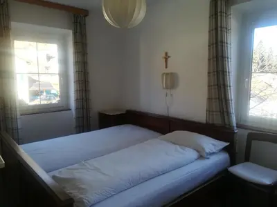 a bedroom with a bed with a cross on the window at Hotel Roen Ruffrè-Mendola in Mendola